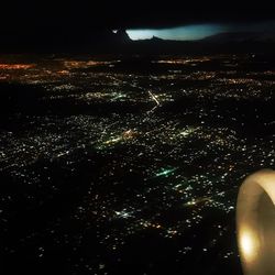 Aerial view of illuminated cityscape against sky at night