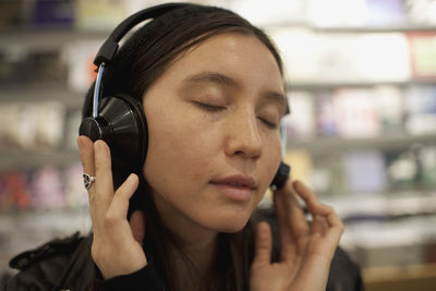 Young woman listening to music in a record store