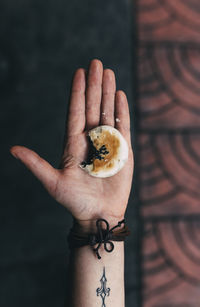 Close-up of hand holding pastry with bite missing
