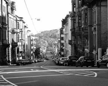 Cars on city street against clear sky