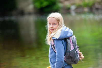 Portrait of girl standing against lake