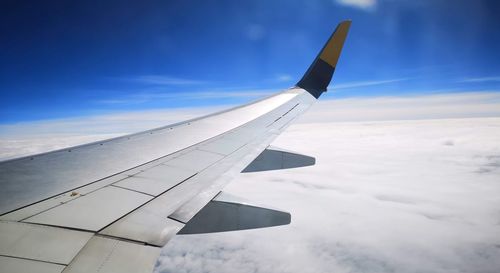 Airplane flying over clouds against sky