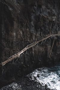 High angle view of mid adult man walking on footbridge by mountain