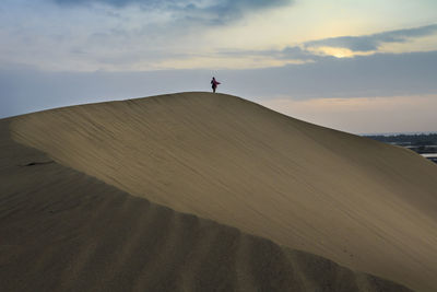 Man standing on sand at beach against sky