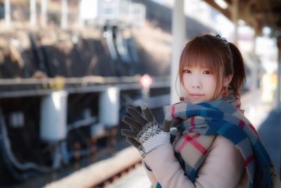 Portrait of cute girl holding camera outdoors