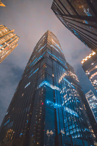 Low angle view of illuminated buildings against sky at night