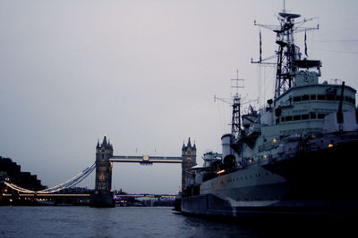 Ship moored at port against sky in city during sunset