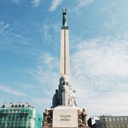 Low angle view of statue of city against cloudy sky