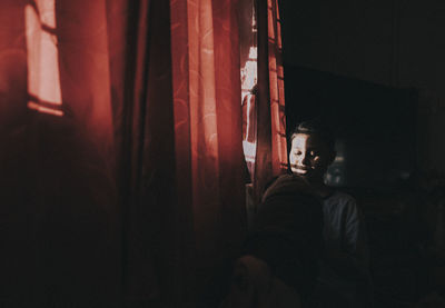 Boy sitting by window at home