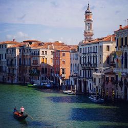 Boats in river with buildings in background