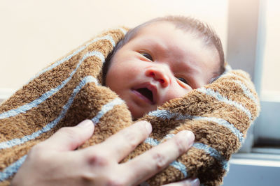 Cropped hand holding newborn baby
