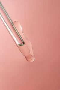 Pipette with cosmetic product in water with bubbles.