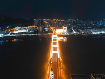 Illuminated buildings in city against sky at night