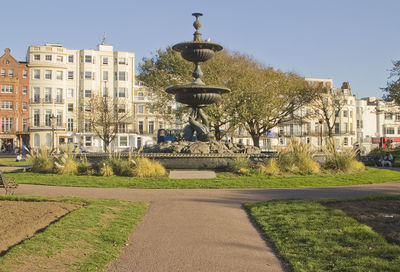 Fountain in city against clear sky