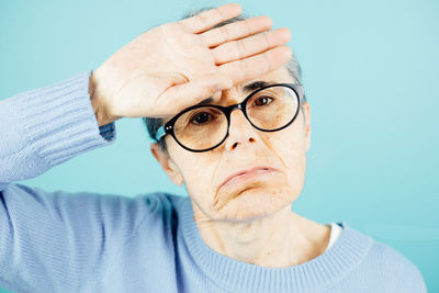 Portrait of man wearing sunglasses against blue background