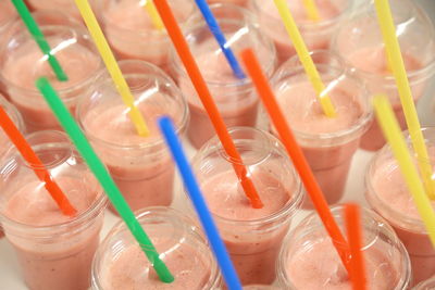 Full frame shot of strawberries smoothie plastic cups