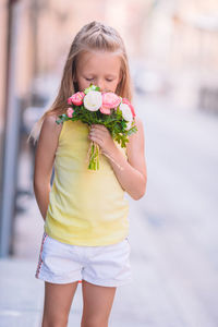 Portrait of smiling young woman standing in city
