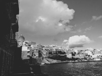 Buildings in city against cloudy sky