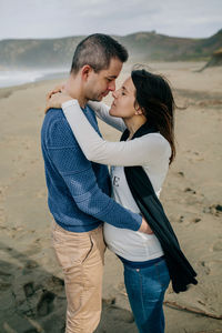 Side view of couple romancing at beach