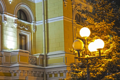 Low angle view of illuminated street light against building