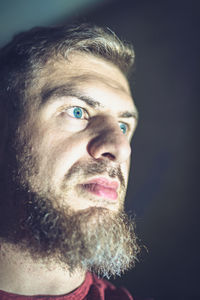 Close-up portrait of man against black background