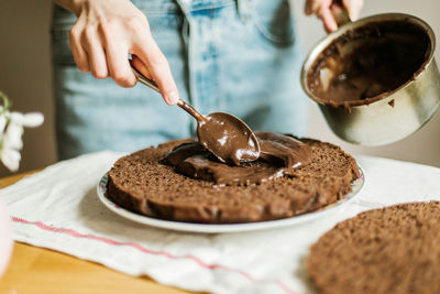 Woman cooking a chocolate cake in kitchen at home.