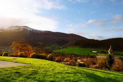 Sunrise shine on green grass field at public park at the hill near city in valley. landscape.