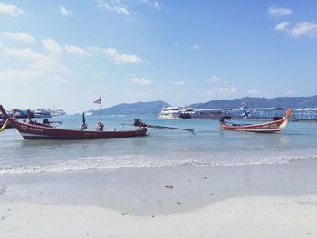 Boats moored on sea against sky