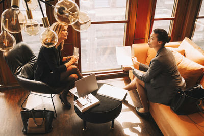 High angle view of female lawyers discussing over documents in office