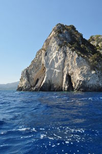 Scenic view of sea and mountains against clear blue sky