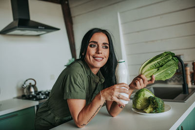 Portrait of woman holding food at home