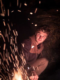 Portrait of young woman with illuminated light painting at night