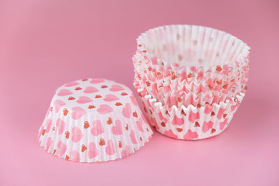 Close-up of cupcakes on table against pink background