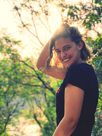 Portrait of smiling young woman standing on field