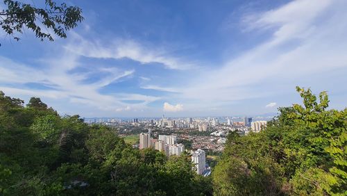 Panoramic view of trees and buildings against sky