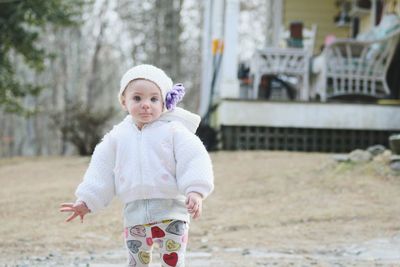 Portrait of cute baby girl standing outdoors