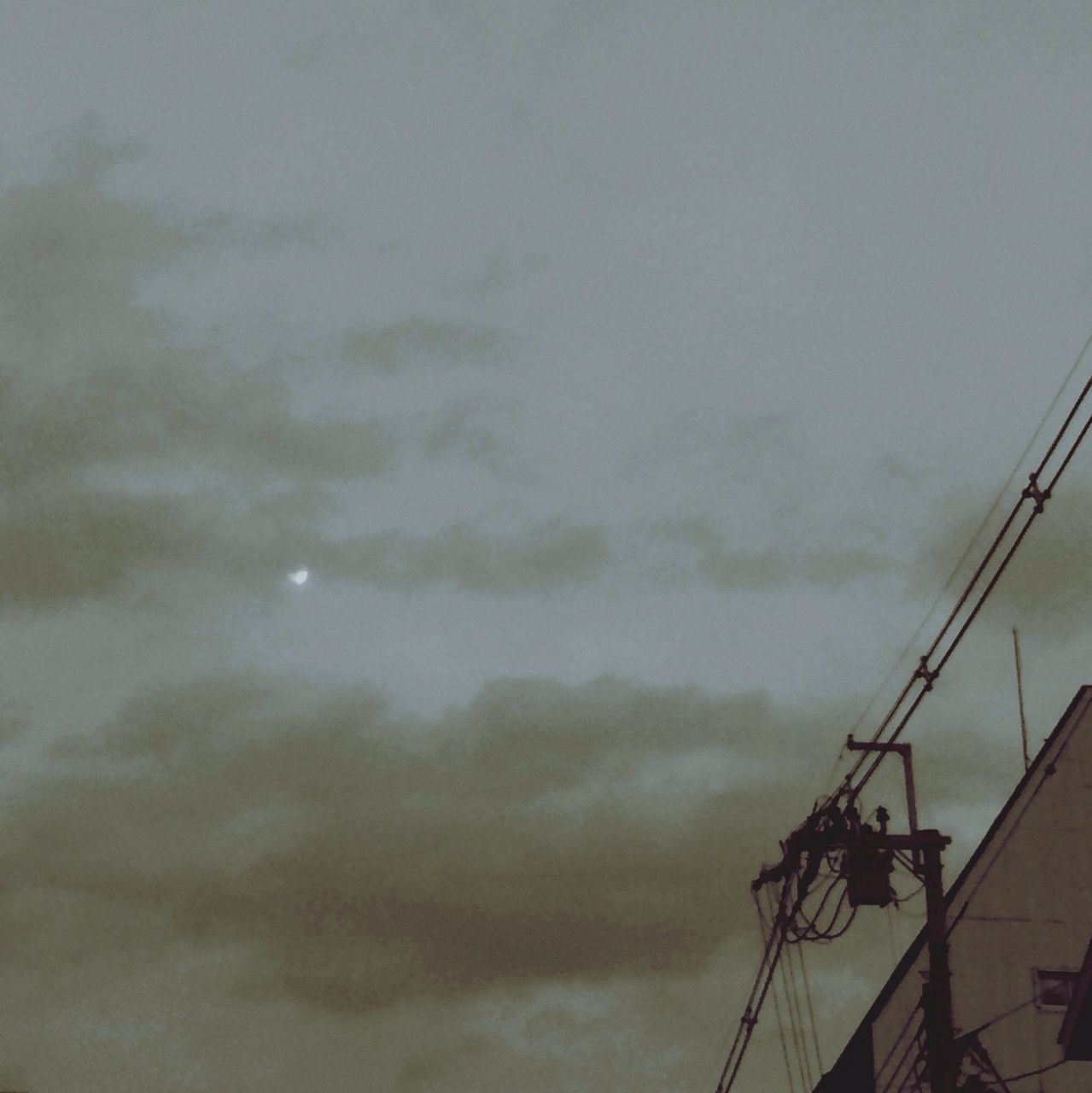 low angle view, sky, cloud - sky, cloudy, silhouette, dusk, built structure, electricity, connection, power line, weather, technology, overcast, lighting equipment, no people, outdoors, architecture, cable, transportation, street light