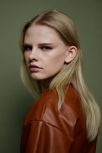 Portrait of young woman against wall