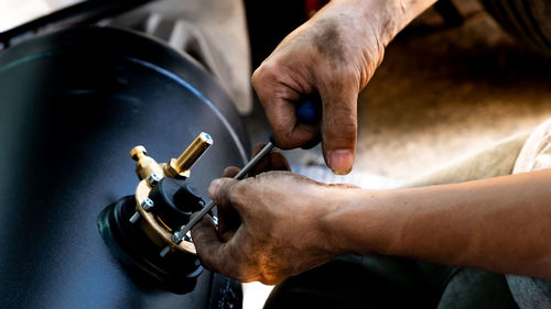 The mechanic is using a hex wrench to reiterate the valve.