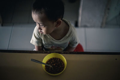 Boy in bowl on table at home