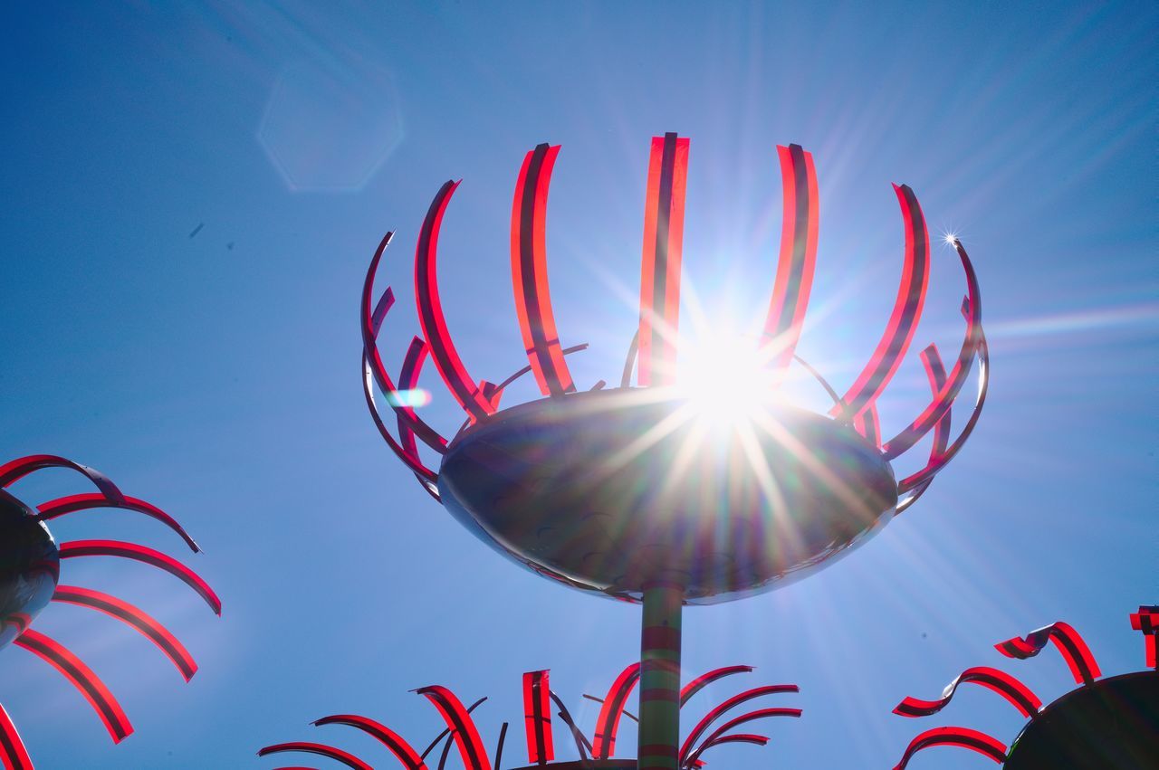 LOW ANGLE VIEW OF SUN SHINING AGAINST BLUE SKY