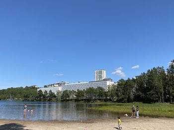 People on lake against sky