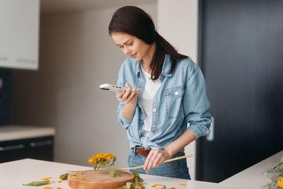 Young woman using mobile phone at home