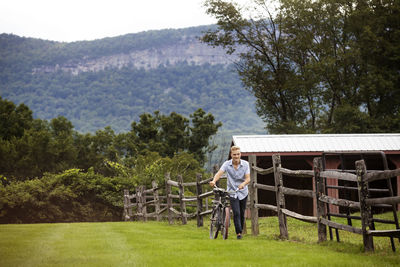 Man walking with bicycle in farm