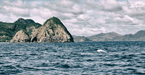 Scenic view of sea and mountains against sky