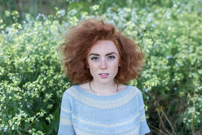 Young woman standing by plants