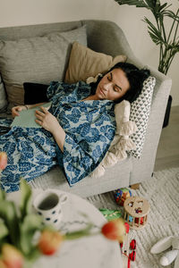 Mid adult woman sleeping on sofa in living room at home