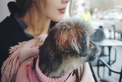 Midsection of woman with dog at cafe