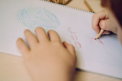 Close-up of hands writing on paper