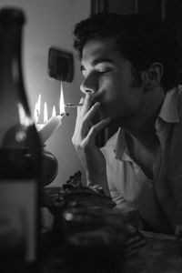 Young man smoking at home